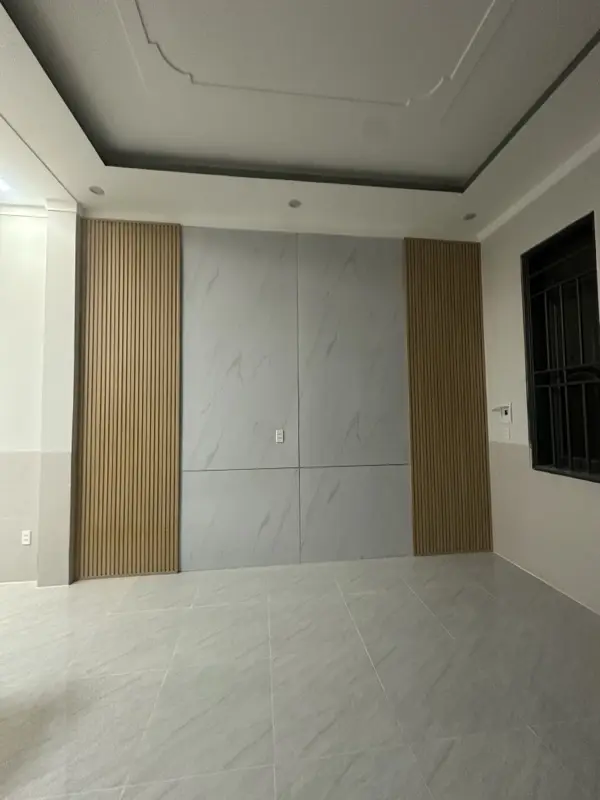 Vách tivi ốp tấm vân đá xám ở giữa, hai bên lam vân gỗ màu sáng