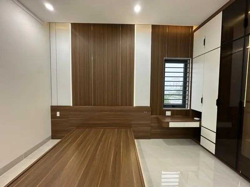 Phòng ngủ: giường bệt vân gỗ, vách đầu giường ốp vân gỗ có LED, tủ áo kịch trần cánh trắng